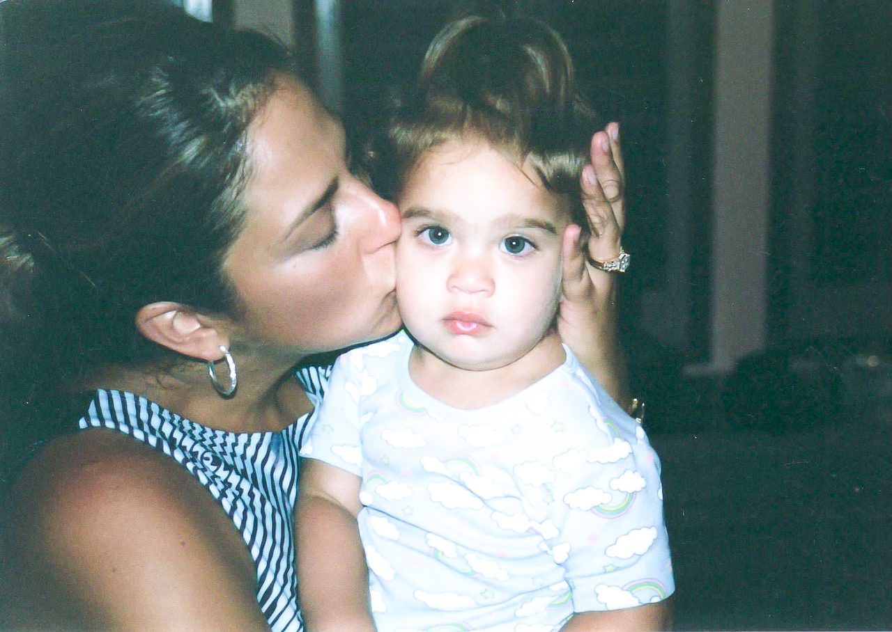 Maria Gabriela Huerta Humpal holding and kissing her daughter Sara as a baby
